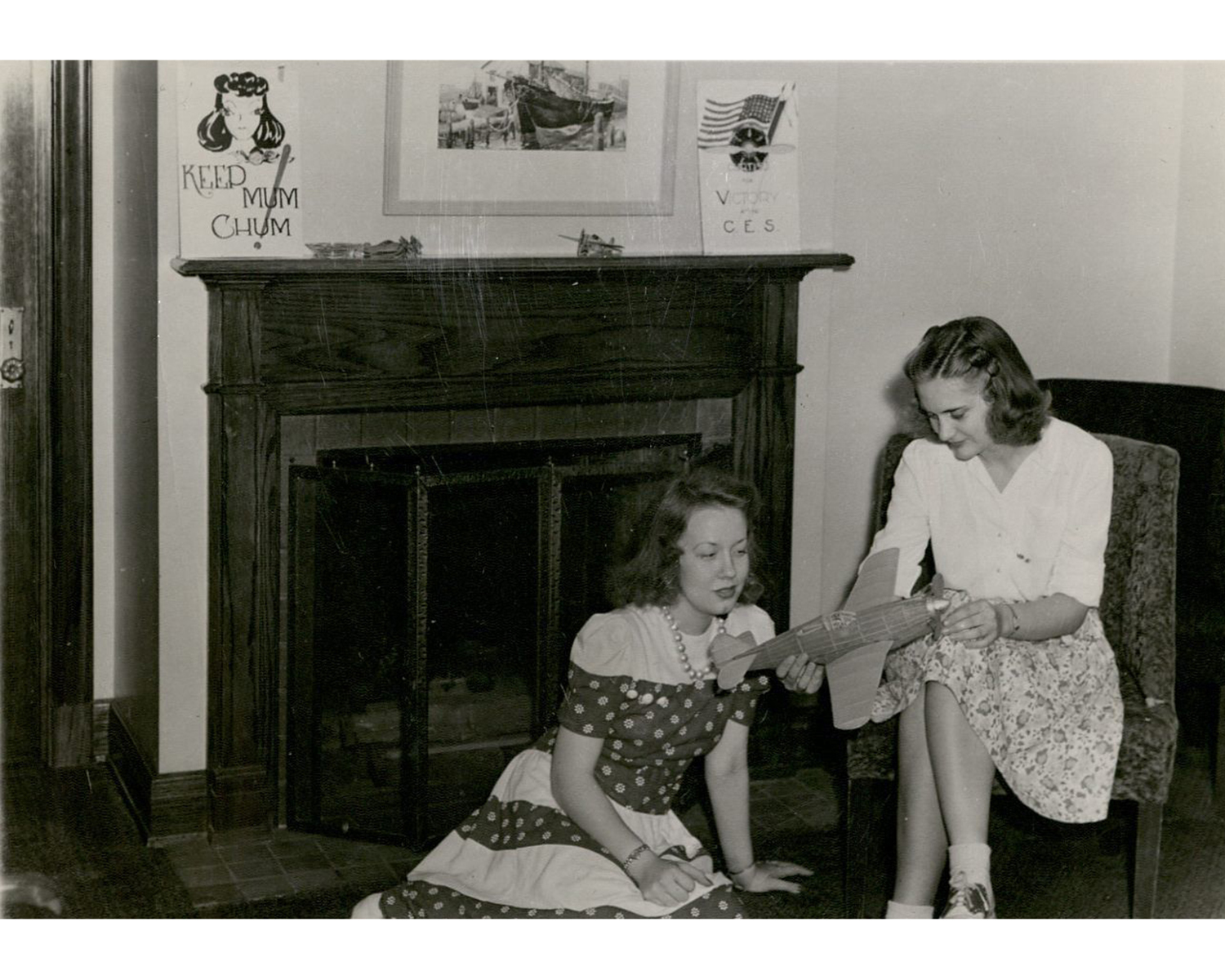 two women inside near a fireplace