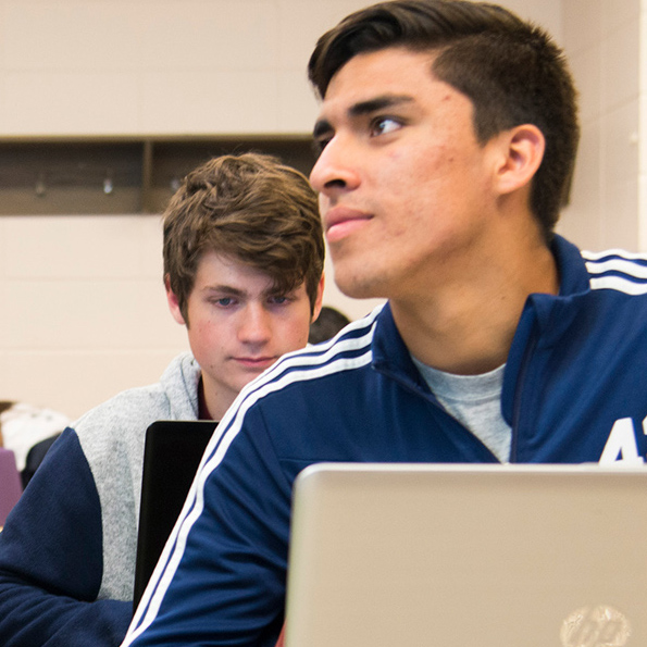 Two students in class with laptop