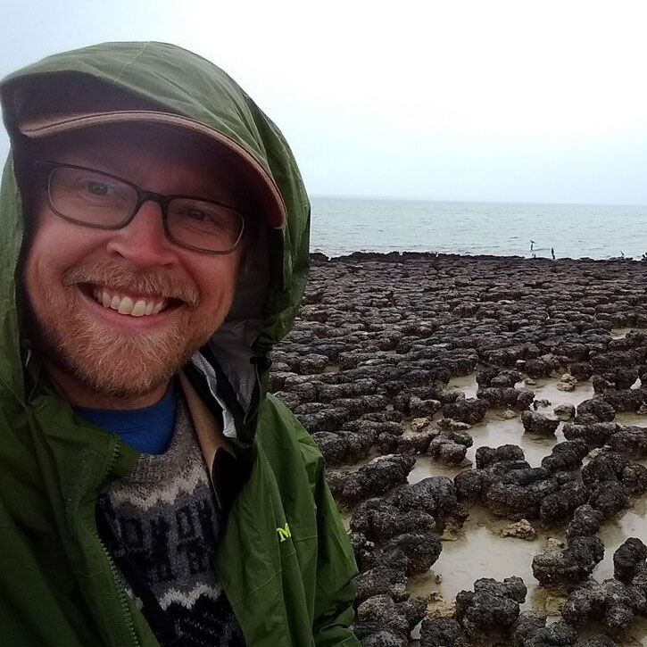 Ben Johnson in foreground. Thrombolites in middle ground of photo.