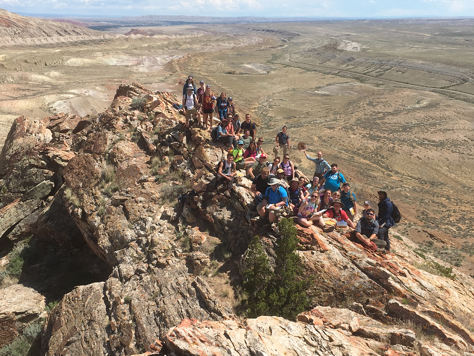 Students in the 2019 summer field camp pose with the Bighorn Basin in the background.