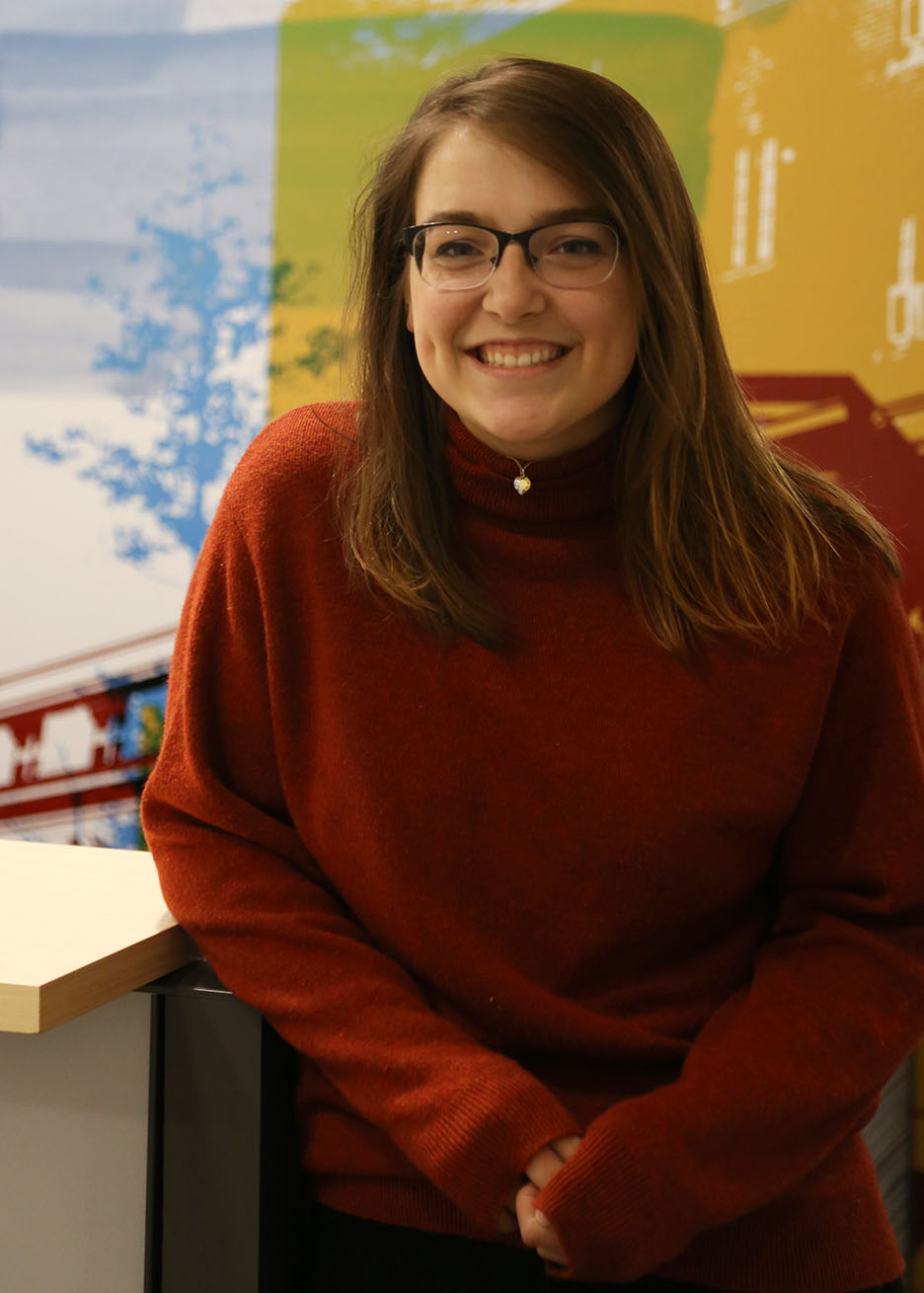 Alex Connor in a read sweater with glasses pictured at the Iowa State Daily