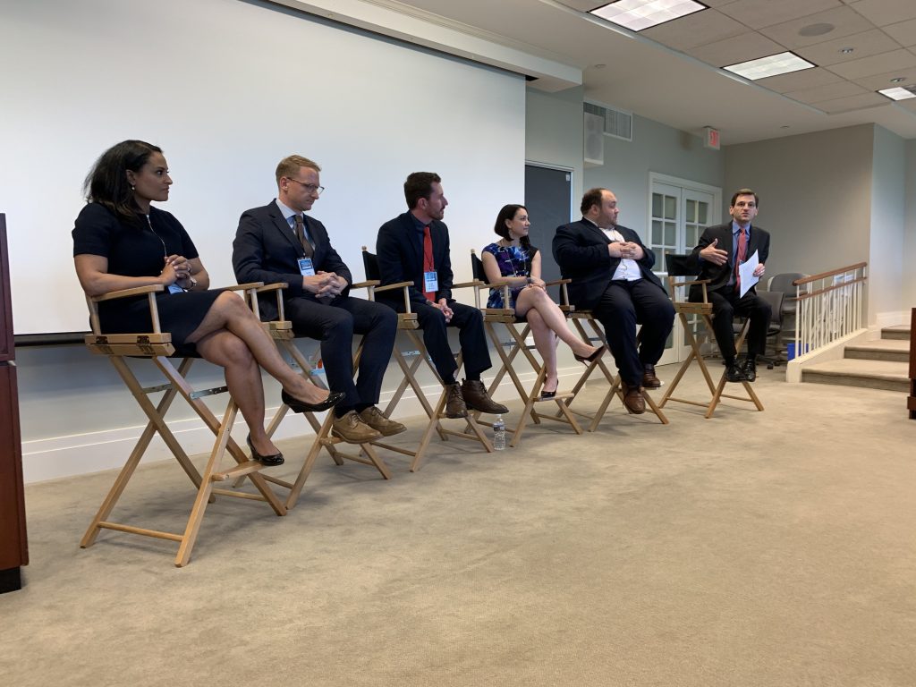 five panelists and a moderator seated at the front of the room