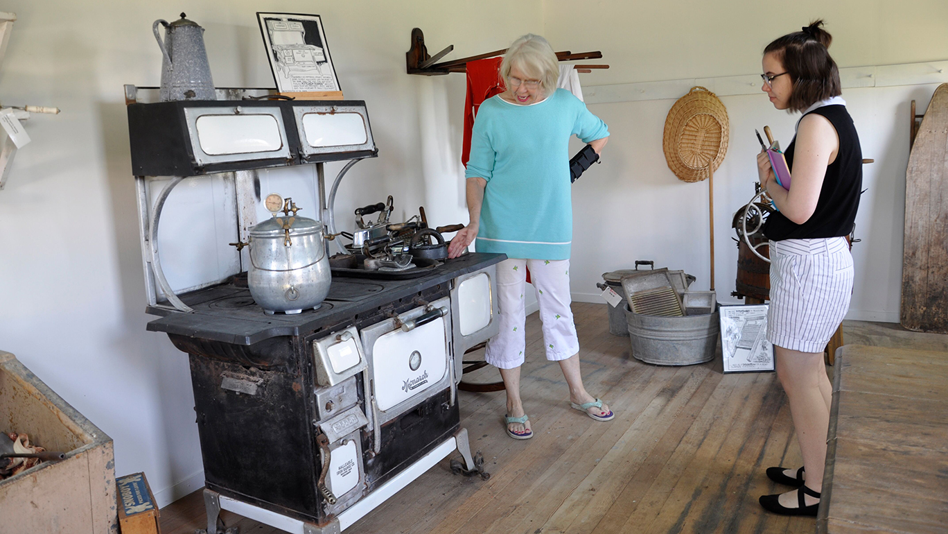 Annelise Wells interviews a woman in front of a vintage stove.