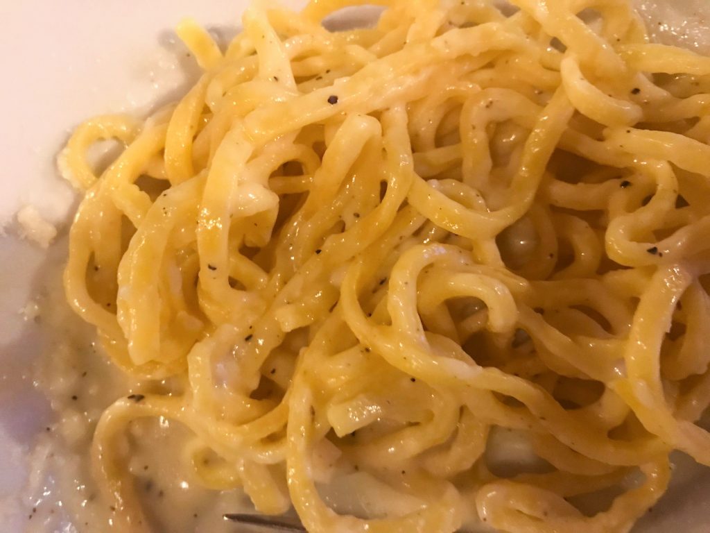 Pasta with cheese and pepper on a white plate