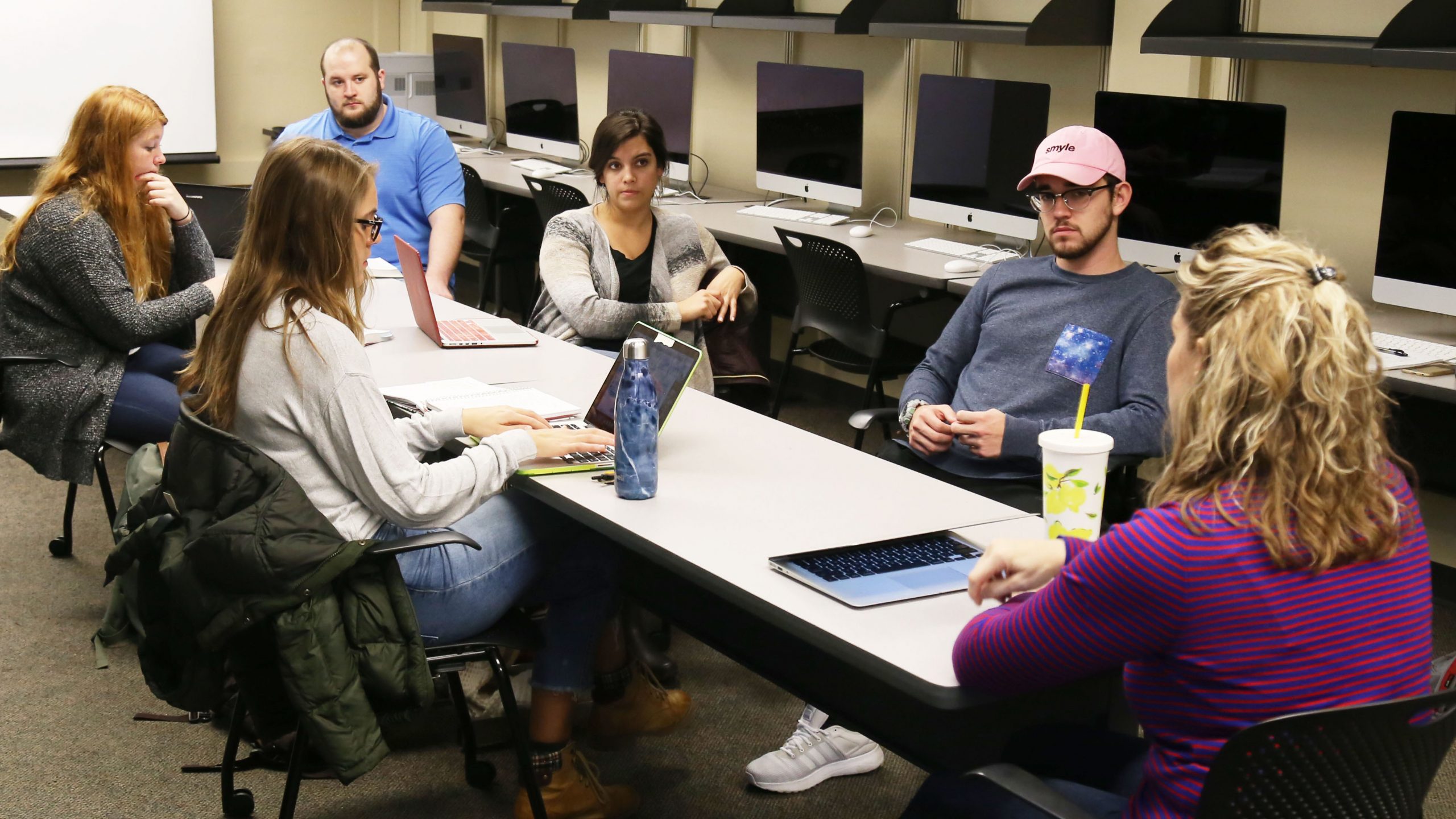 five students--three women and two men--and professor Lisa Oakes gathered around a table in a computer lab