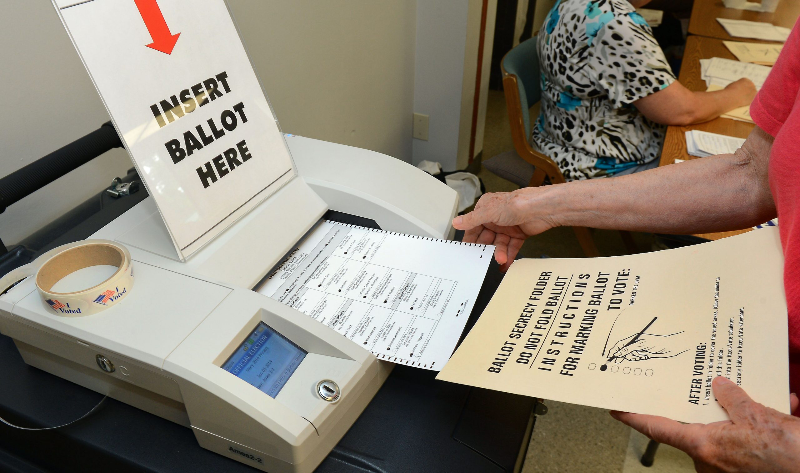photo of a paper ballot being inserted into a machine