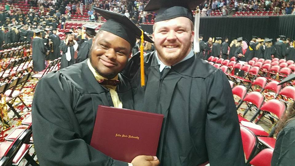 Malik with his diploma and a friend at graduation