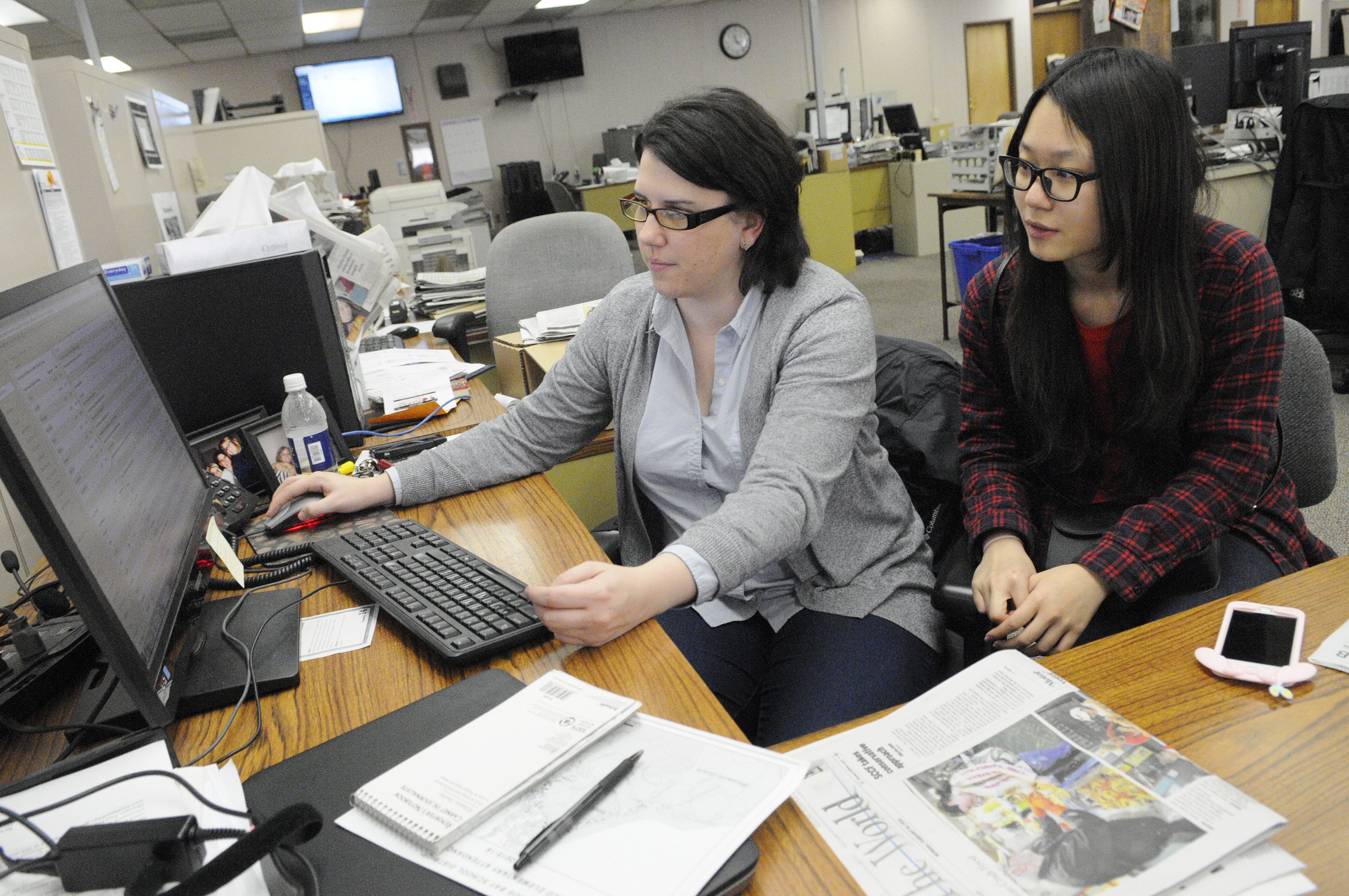 Chelsea Davis, ’12, digital editor at The World newspaper in Coos Bay, Ore., works with a Chinese exchange student during a half-day job shadow. Courtesy of Chelsea Davis