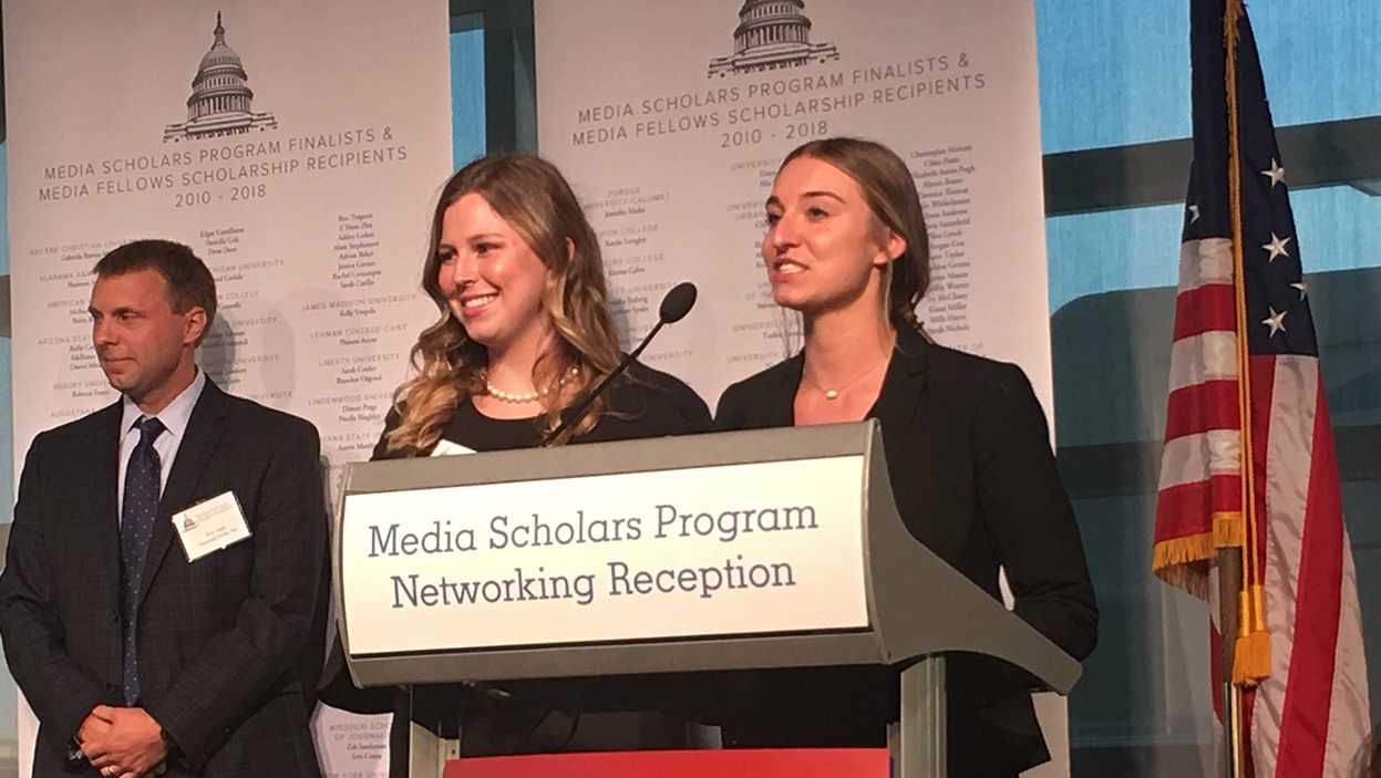 Ashley Kirkpatrick and Lindsey Moor stand at podium