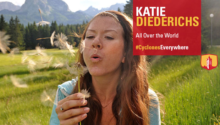 Katie Diederichs blows a dandelion in a field