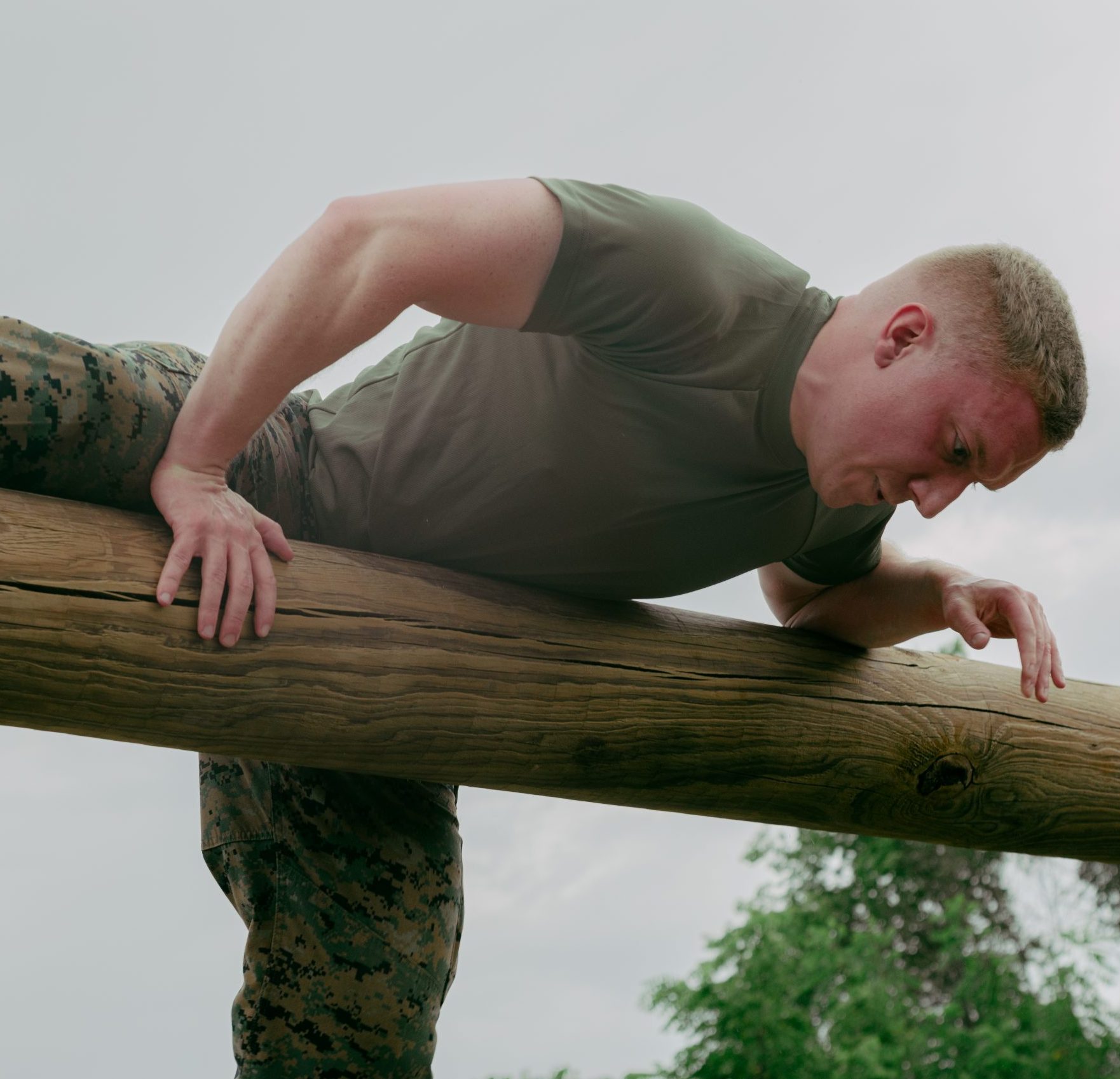 ROTC student climbs over wooden beam