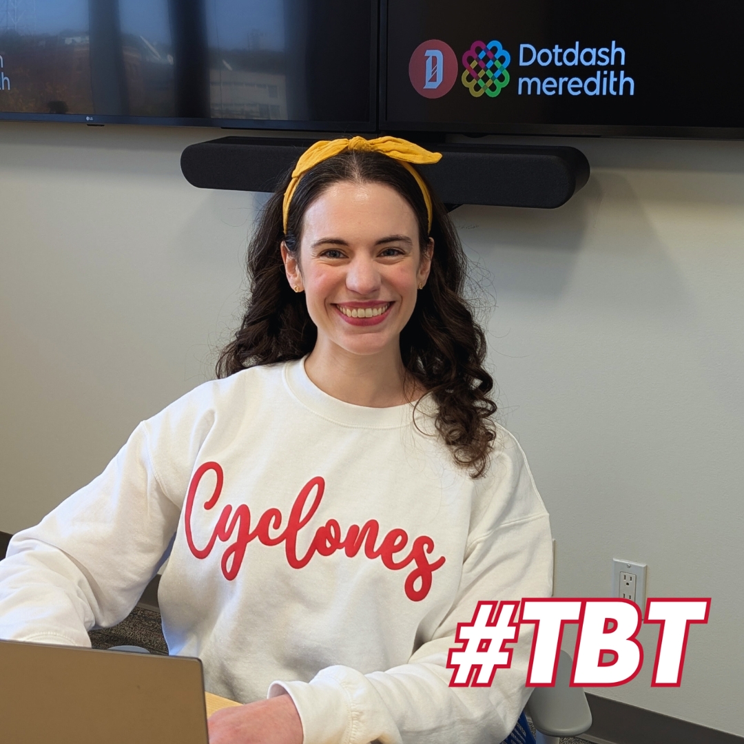 Annamarie Knief, alumni in English, wearing a white crew neck with a cursive "Cyclones" logo on the front. She is seated in front of a television screen showing the Dotdash Meredith logo. There is an overlay graphic in white and outlined in red that says "#TBT"