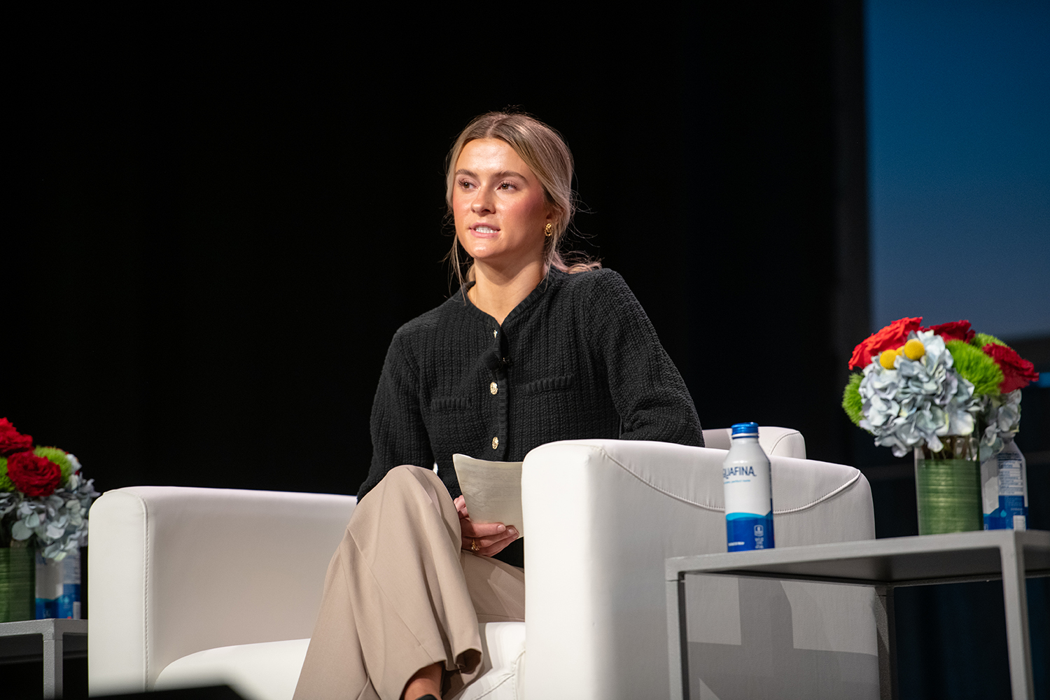 Kathleen Hepworth, senior in public relations, seated on white arm chair speaking to audience off-camera.