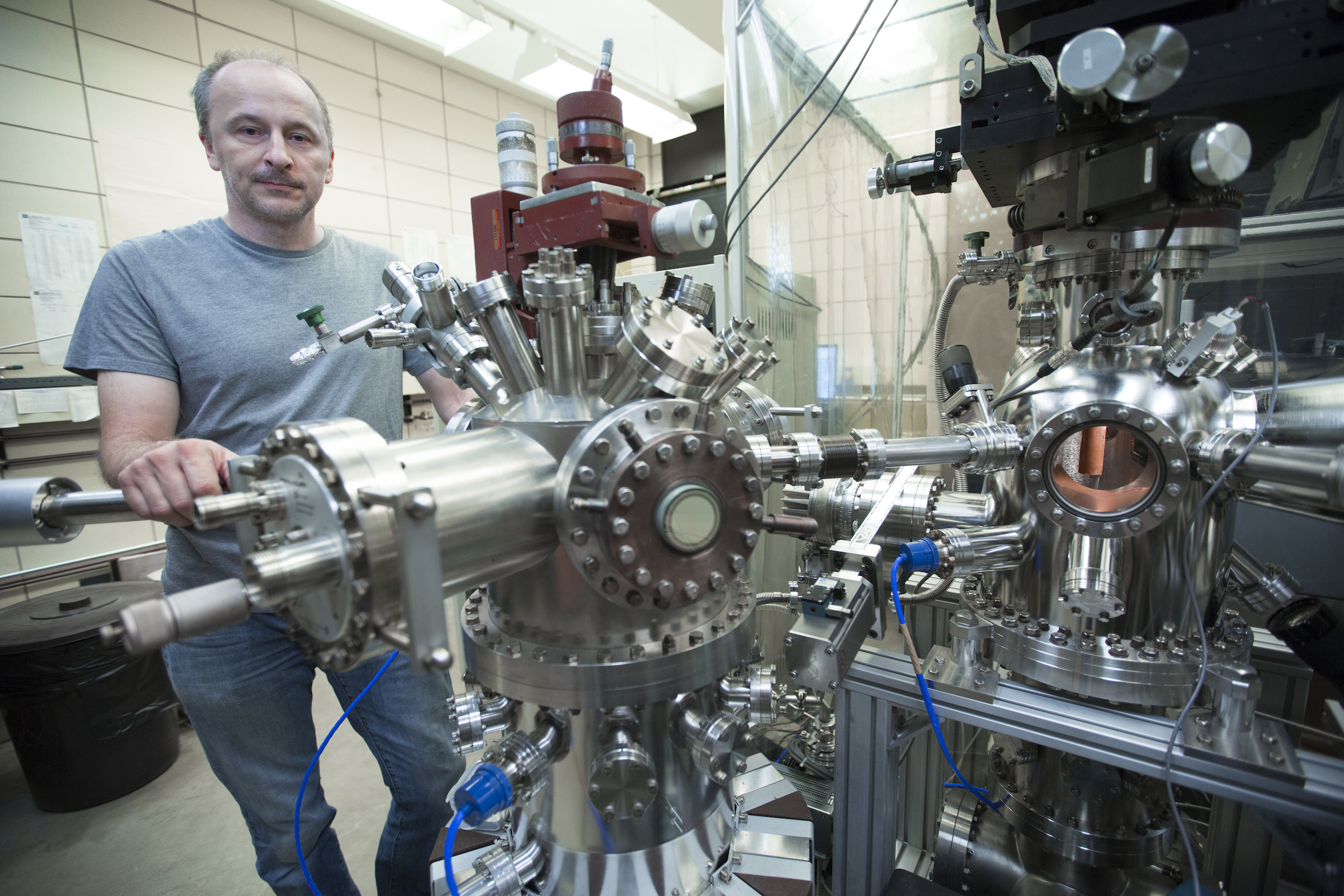 Adam Kaminski stands behind the laser machine he built.