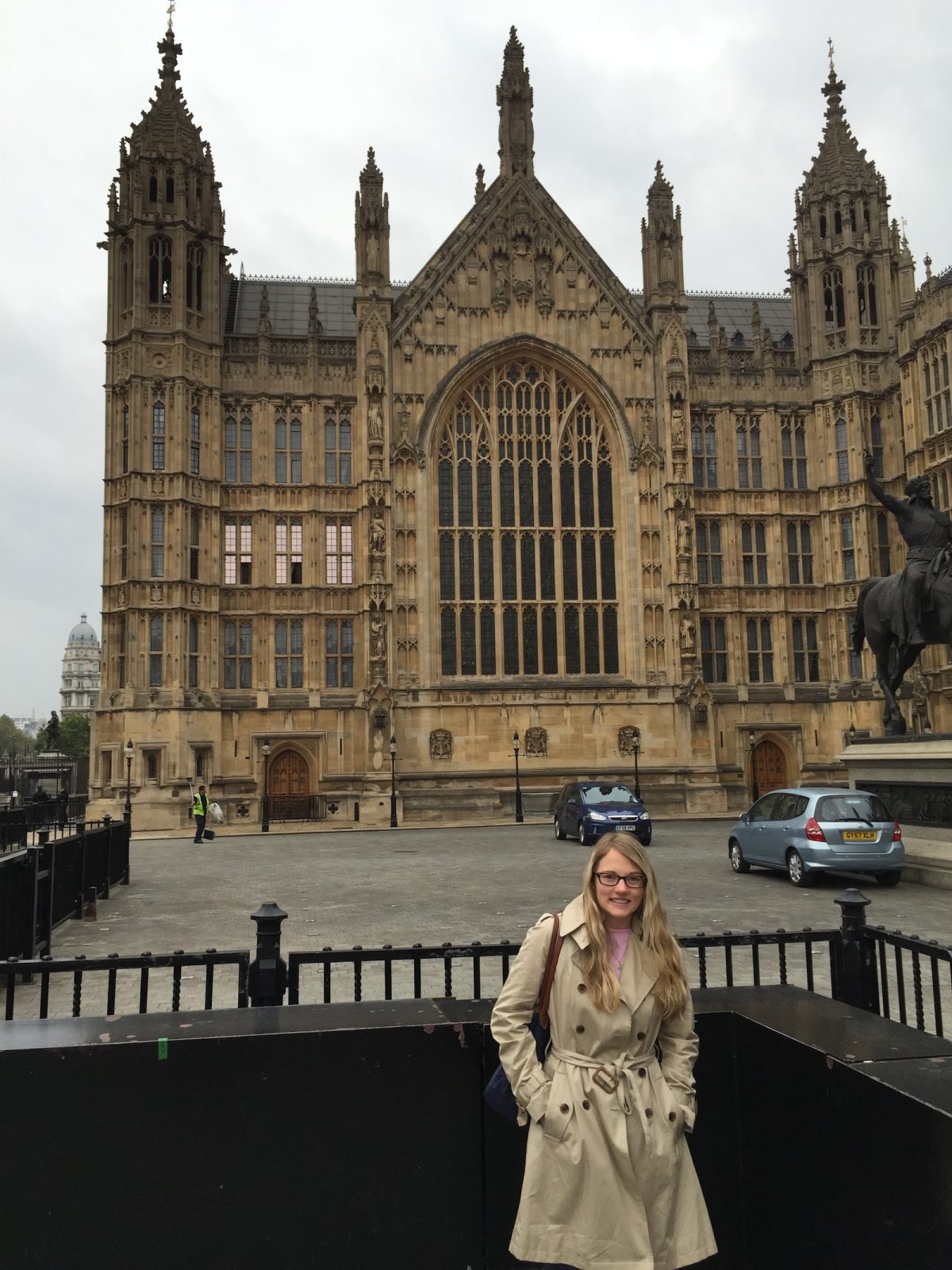 Samantha clark on the foreground with a historic building behind her on the streets of London.