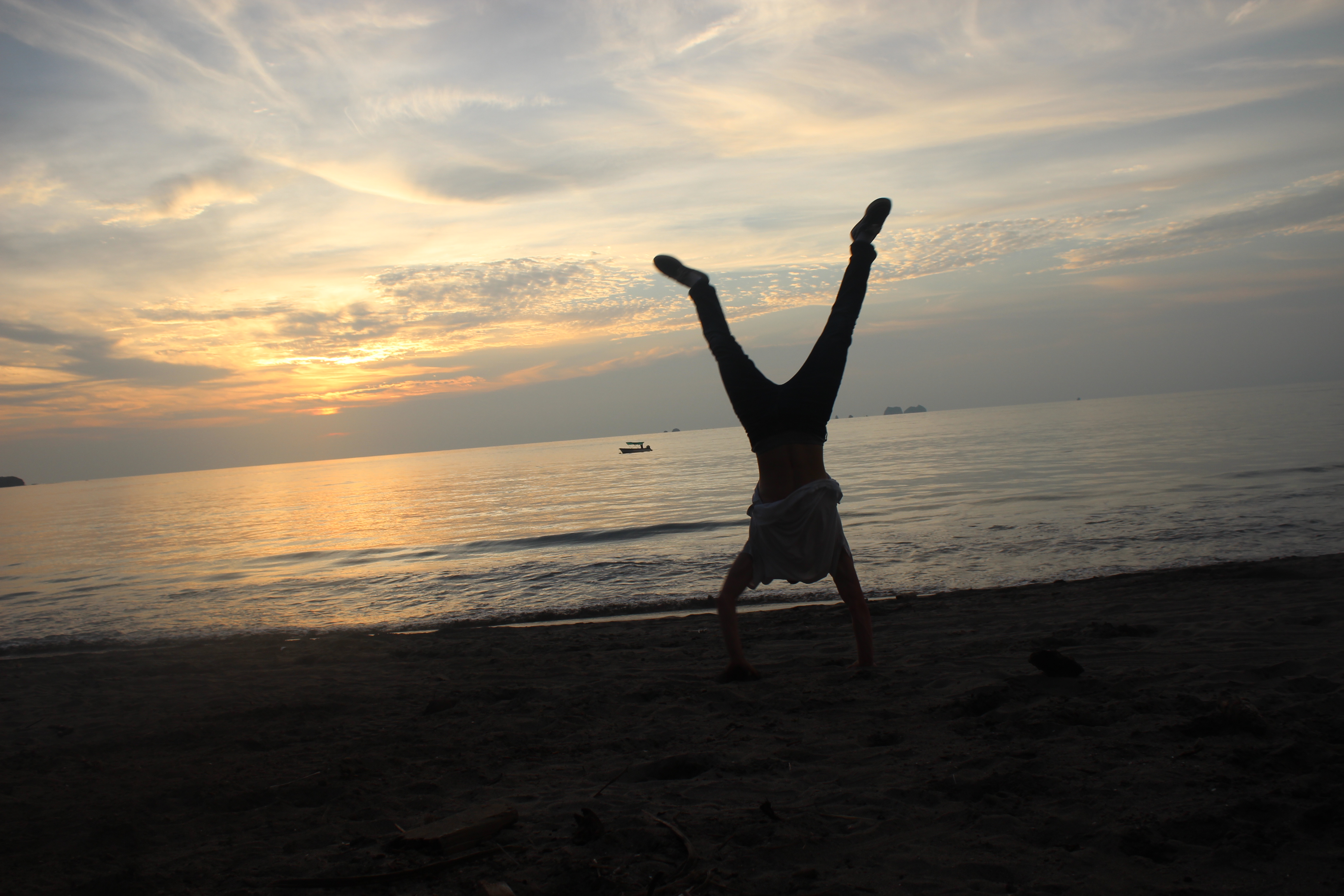Student does a cartwheel on the beaches of Costa Rica at sunset.