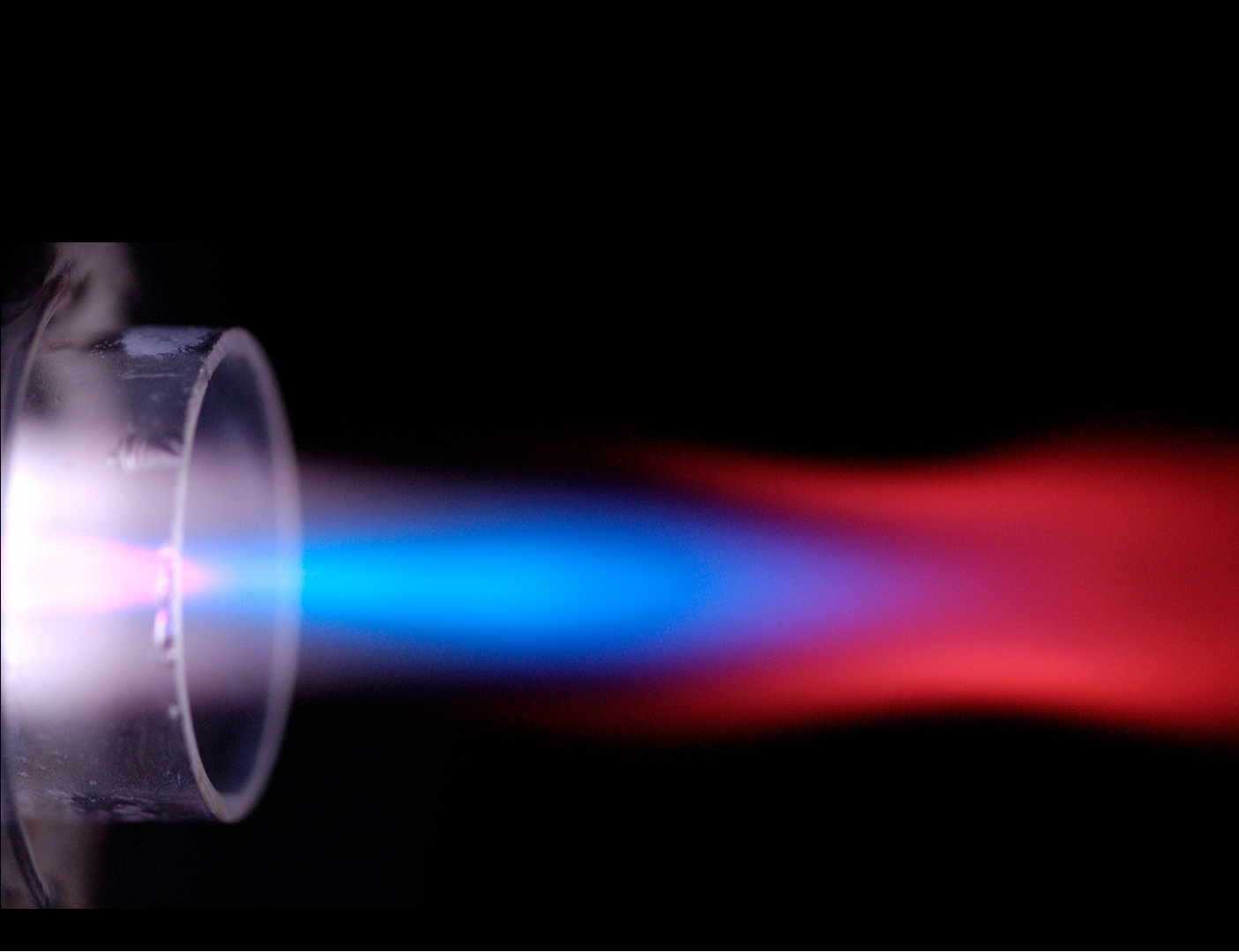 Plasma flows from left to right, containing a sample of yttrium nitrate. The red colored regions are emission from YO molecules and the blue region is from Y+ ions. In ICP-MS, the sampler cone tip would be just to the right of the end of the first red region.