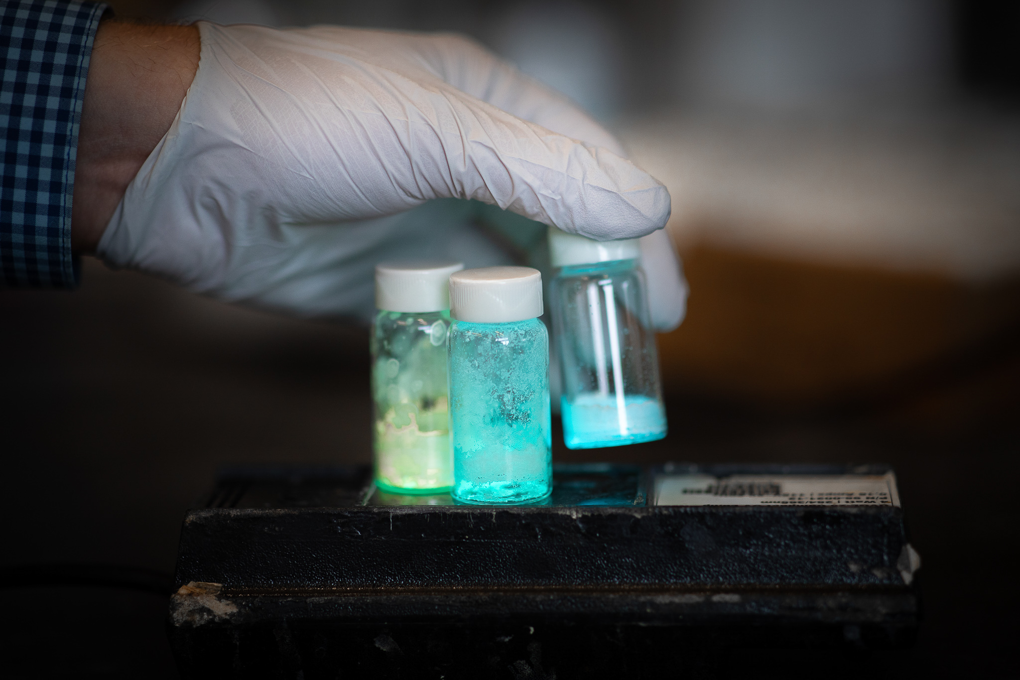 Glowing powders fill small glass jars in the VanVeller research lab