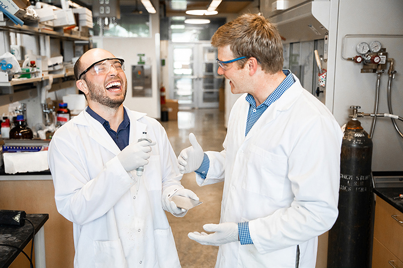 Brett VanVeller and his student Luis Camacho laugh as they discuss photochemistry research