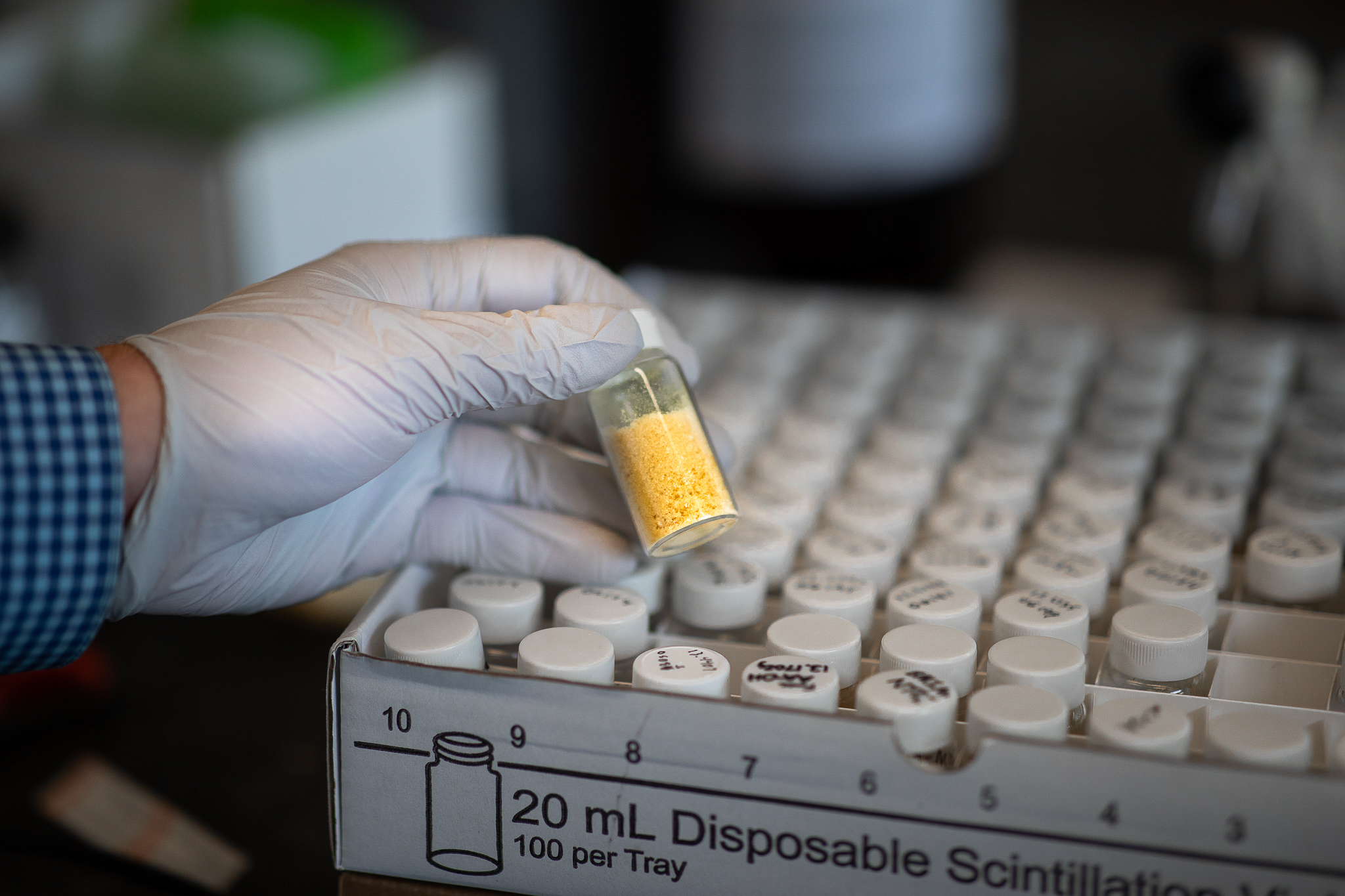 a glass vial of yellow powder in the chemistry lab