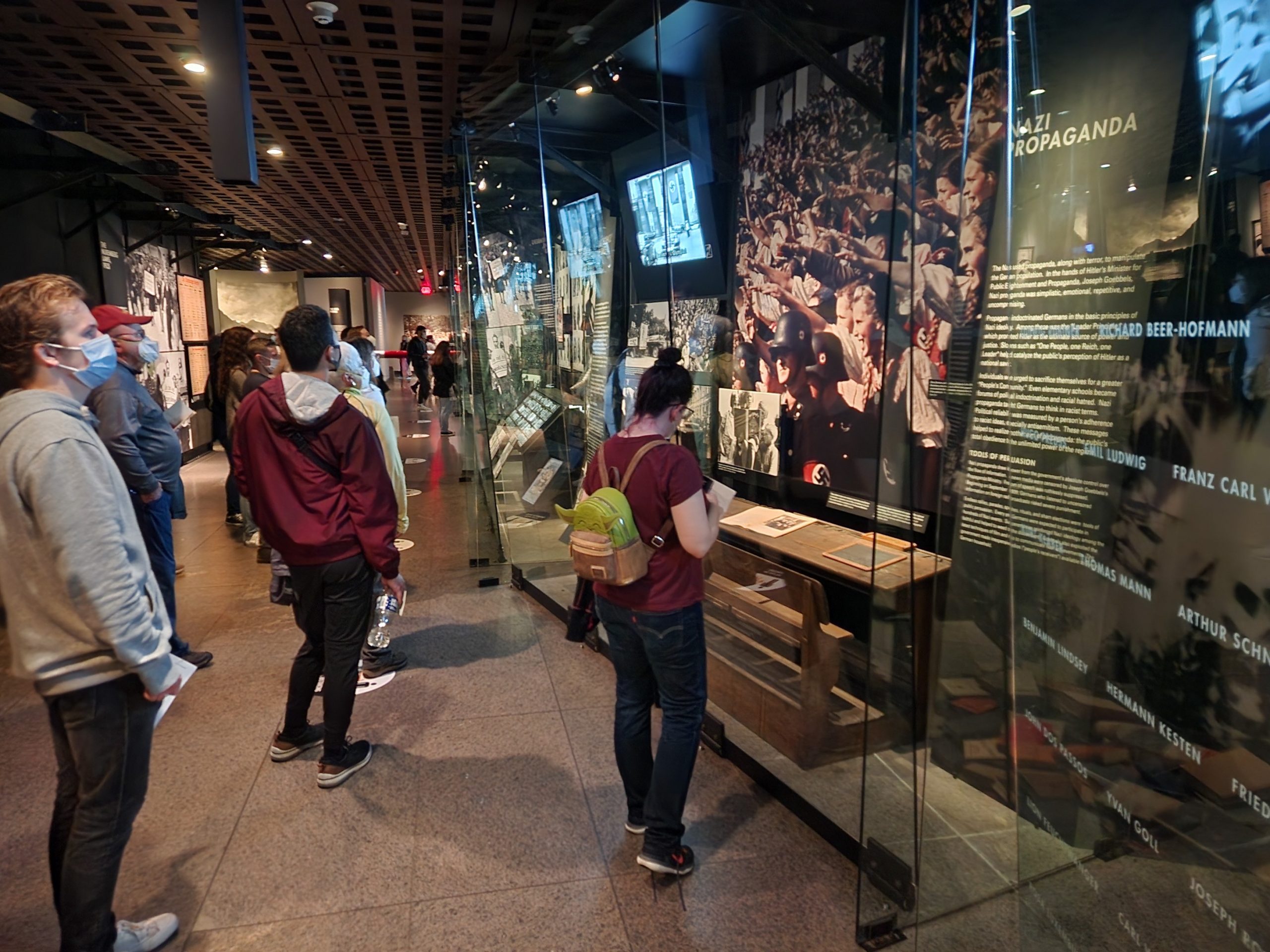 Students view an exhibit on Nazi propaganda at the United States National Holocaust Memorial Museum.
