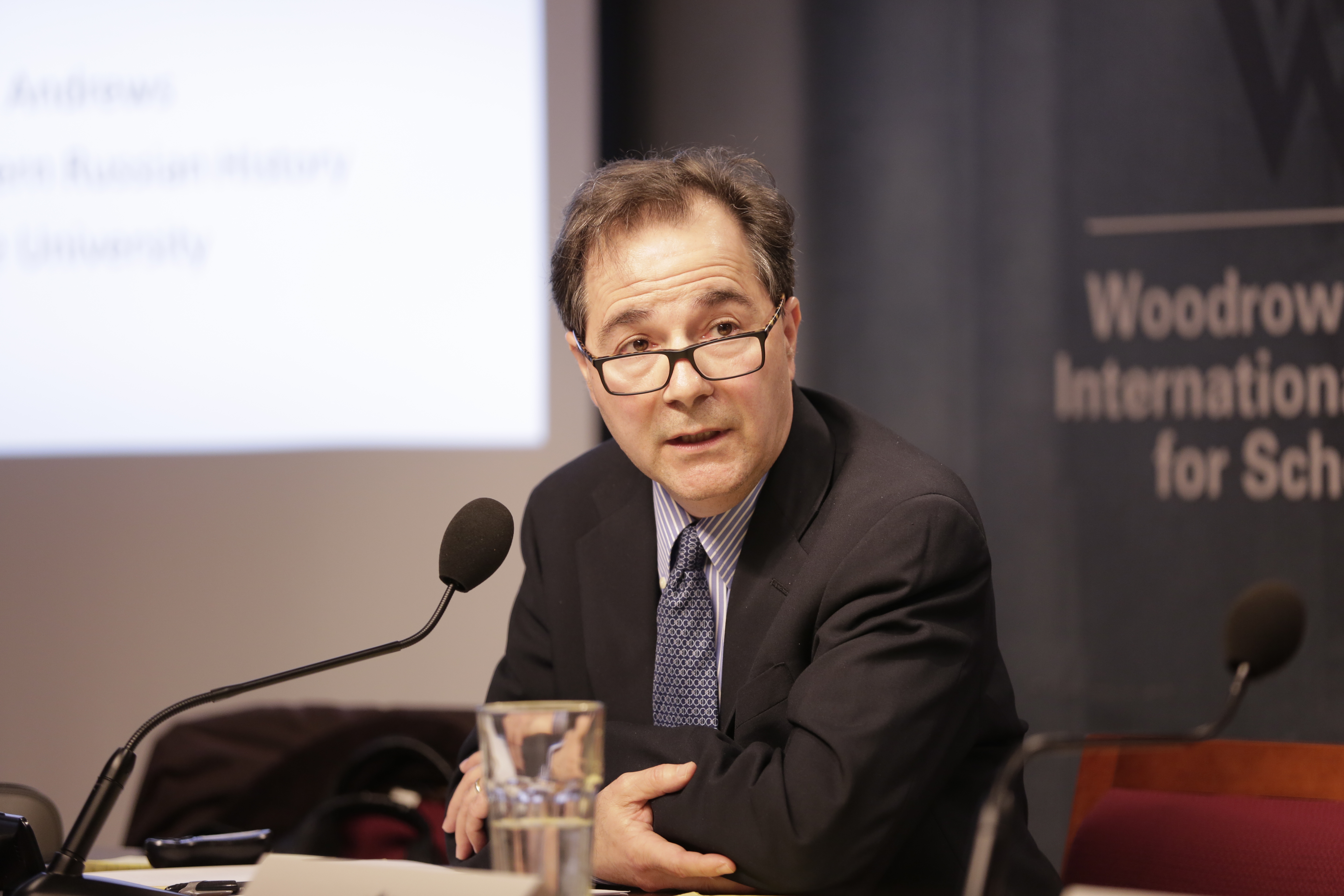 James Andrews seated at a table with microphone.