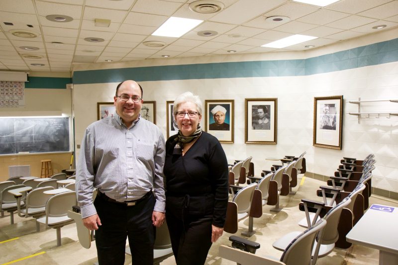 Javier Vela and Renee Harris with the portraits of distinguished scientists in Gilman 1352.