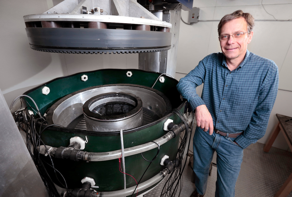 Neal Iverson stands beside a large machine.