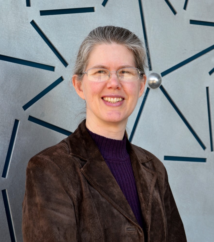 A portrait style photo of Theresa Windus in front of the chemistry building wall.