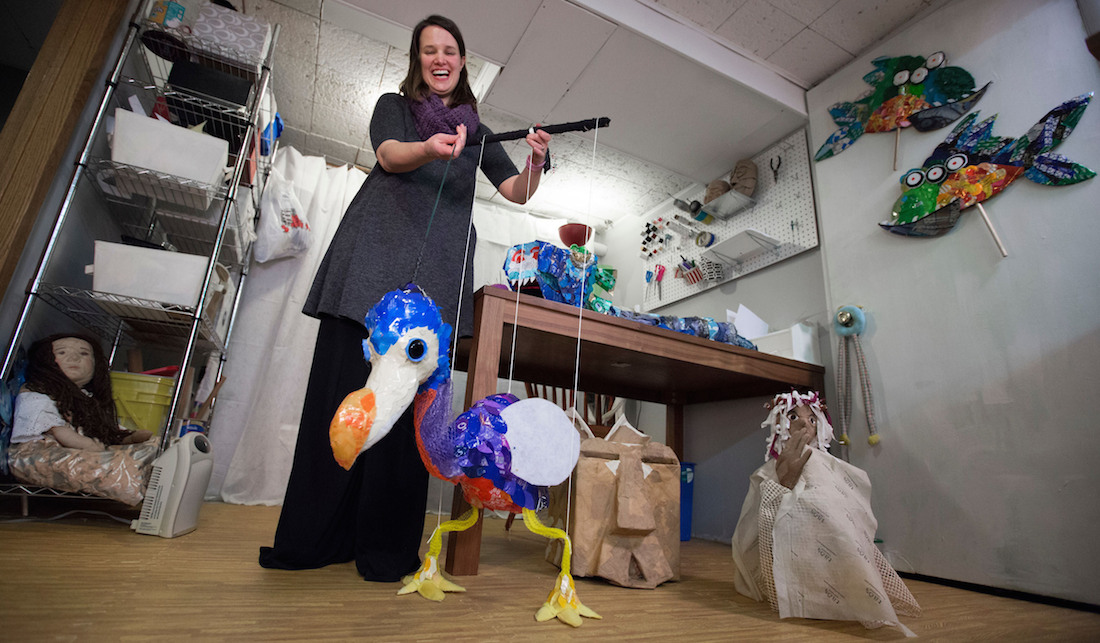 Amanda Petefish holds a string puppet of a bird.