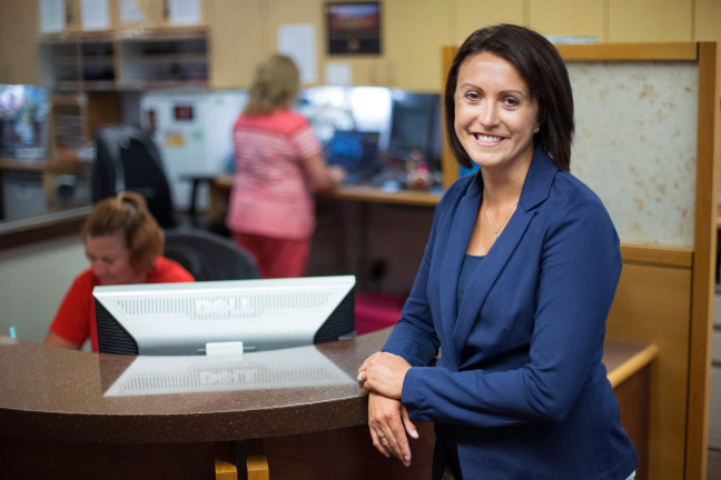 Katherine Rafferty stands at a hospital reception desk.