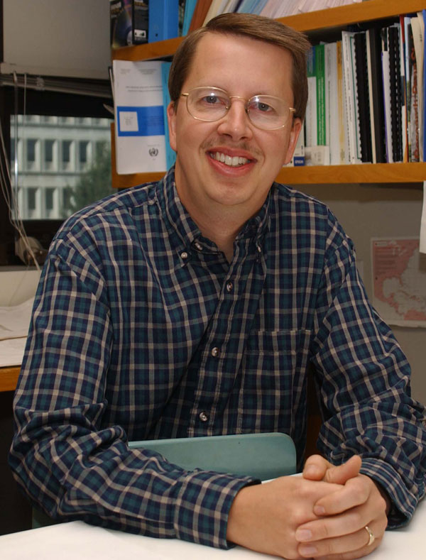 Bill Gallus in his office with books behind him.