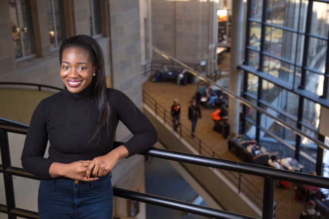 Grace Ansah leans against the railing in Parks Library.