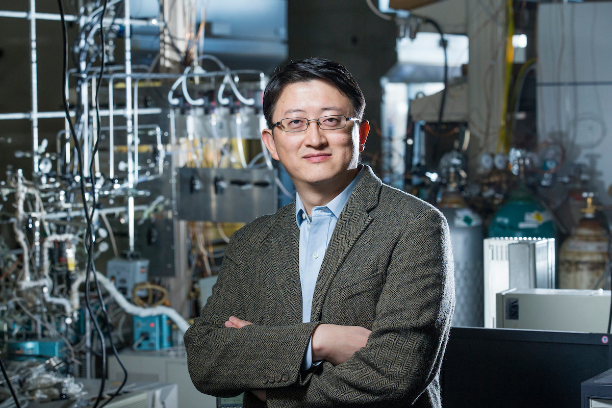 Wenyu Huang stands in a chemistry lab.