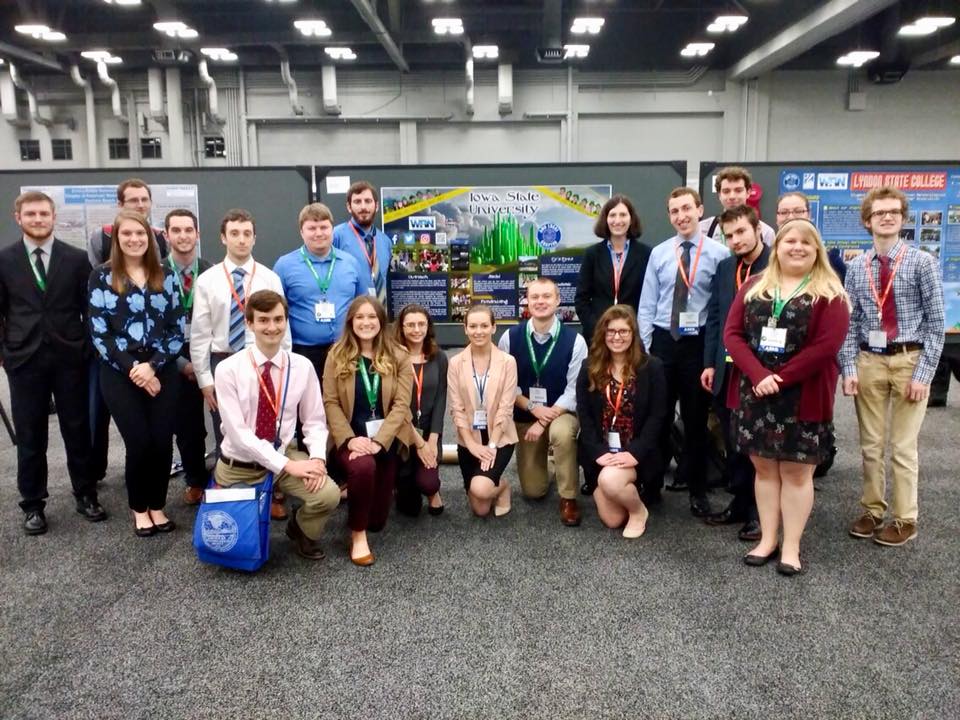 Many students stand around a large poster.