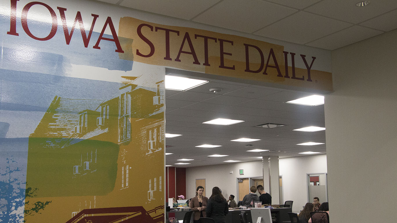 photo of Daily newsroom with logo in foreground and students in background