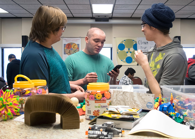 Students stand around a counter with gadgets.