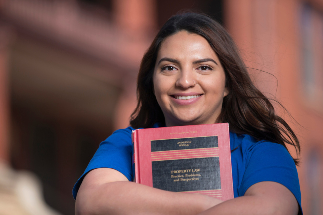 Jacqueline Garcia holds a textbook outside