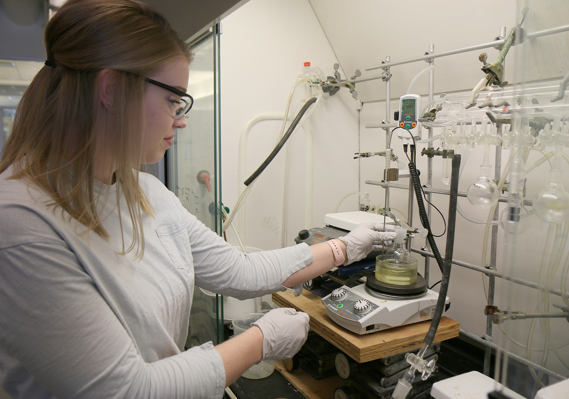 Grace Lutovsky works under a chemistry hood.