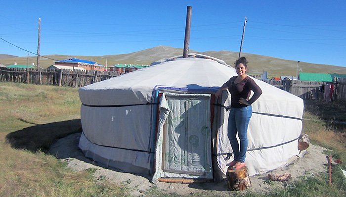 Sarah Hiller stands outside a tent.