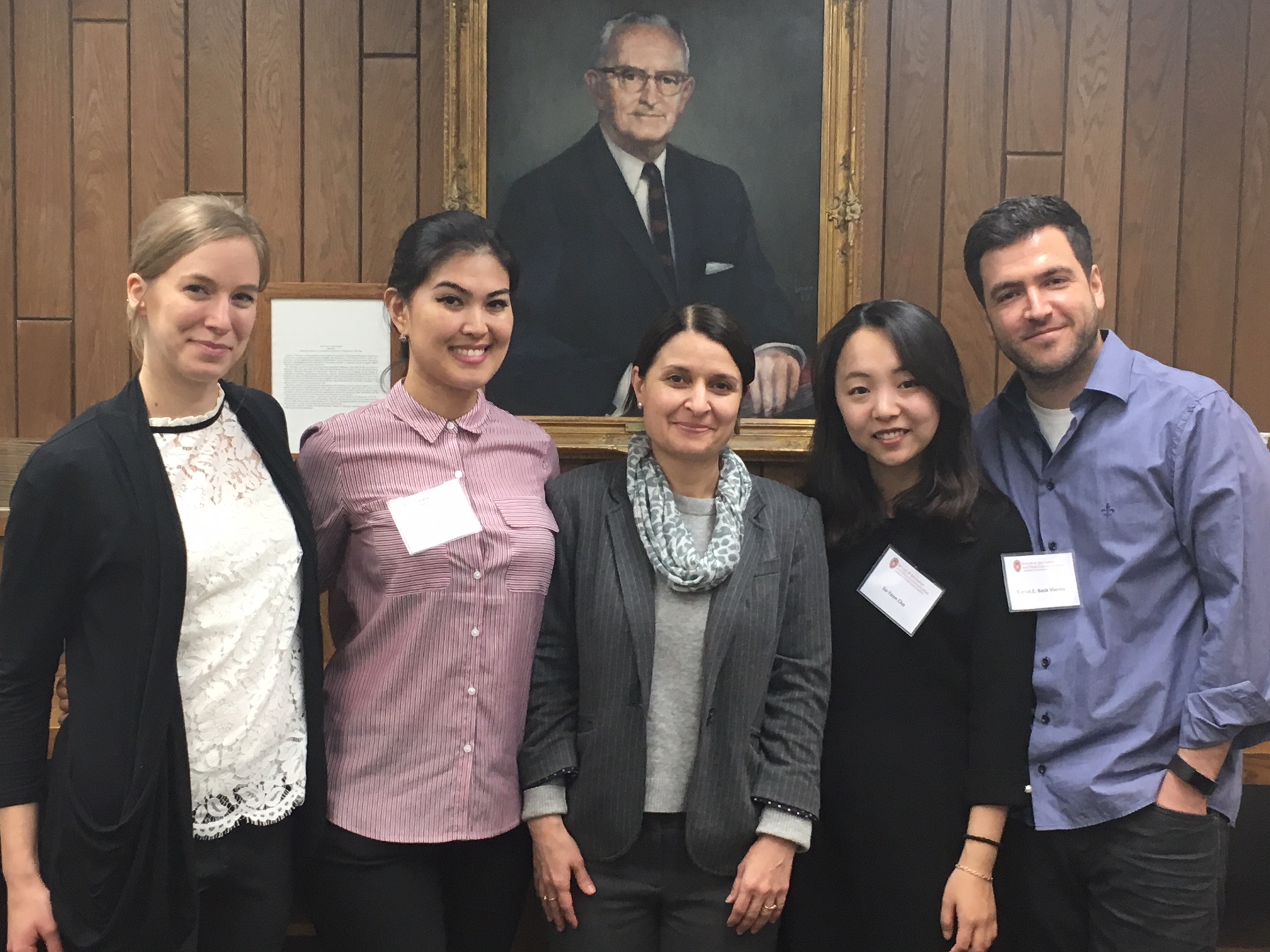 Students pose with Daniela Dimitrova in front of a portrait.