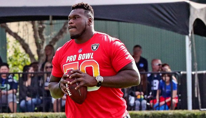 Kelechi Osemele outside holding a football.