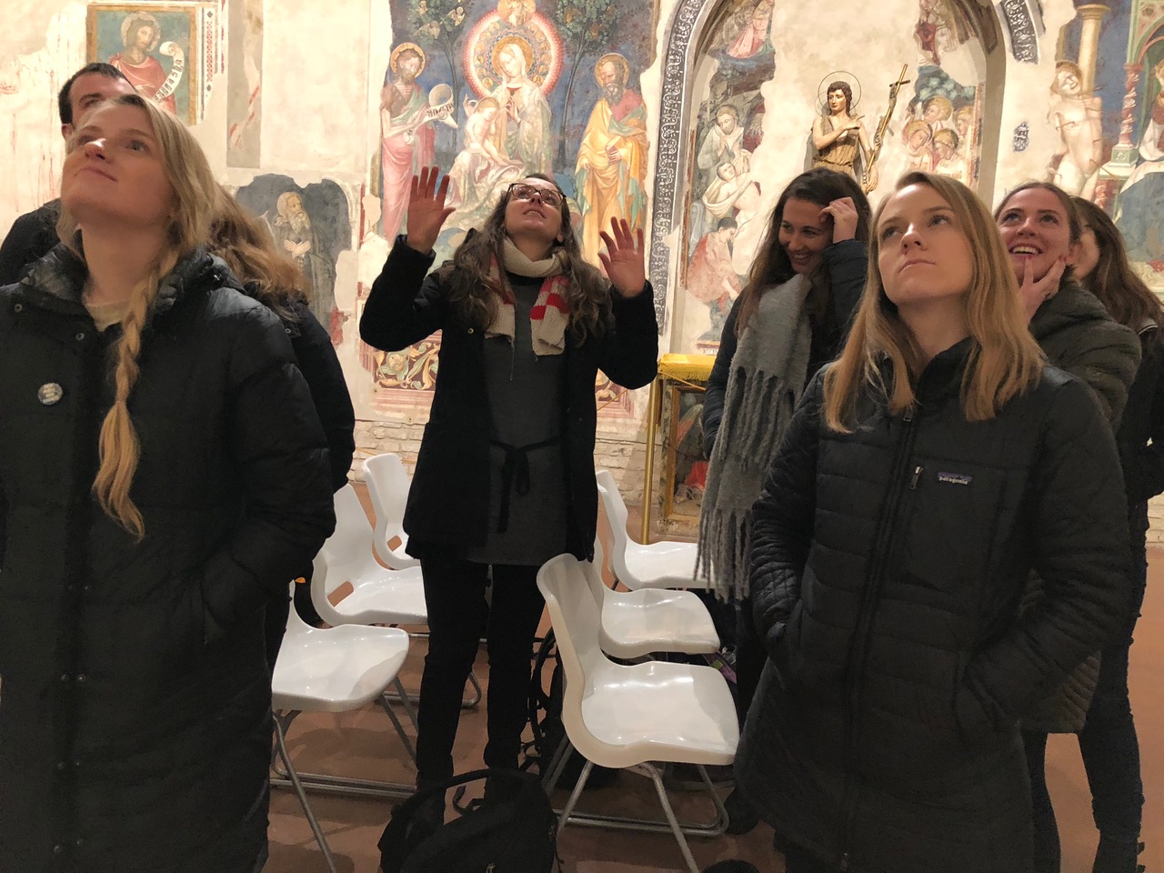 Students look at frescos on walls.