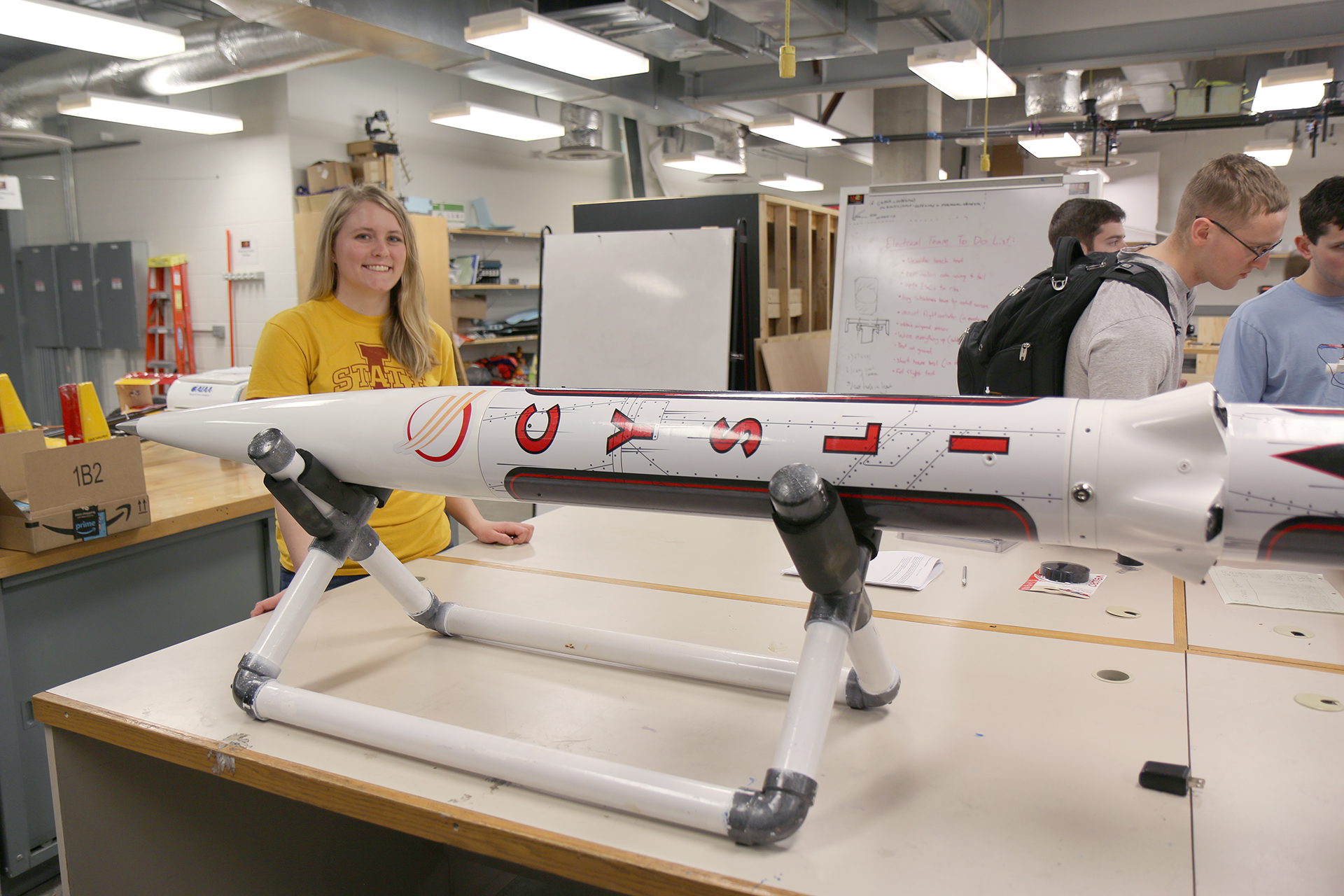 A young woman with a rocket on a table.