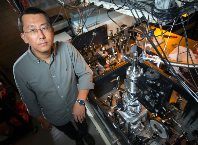 Jigang Wang stands in front of machinery.