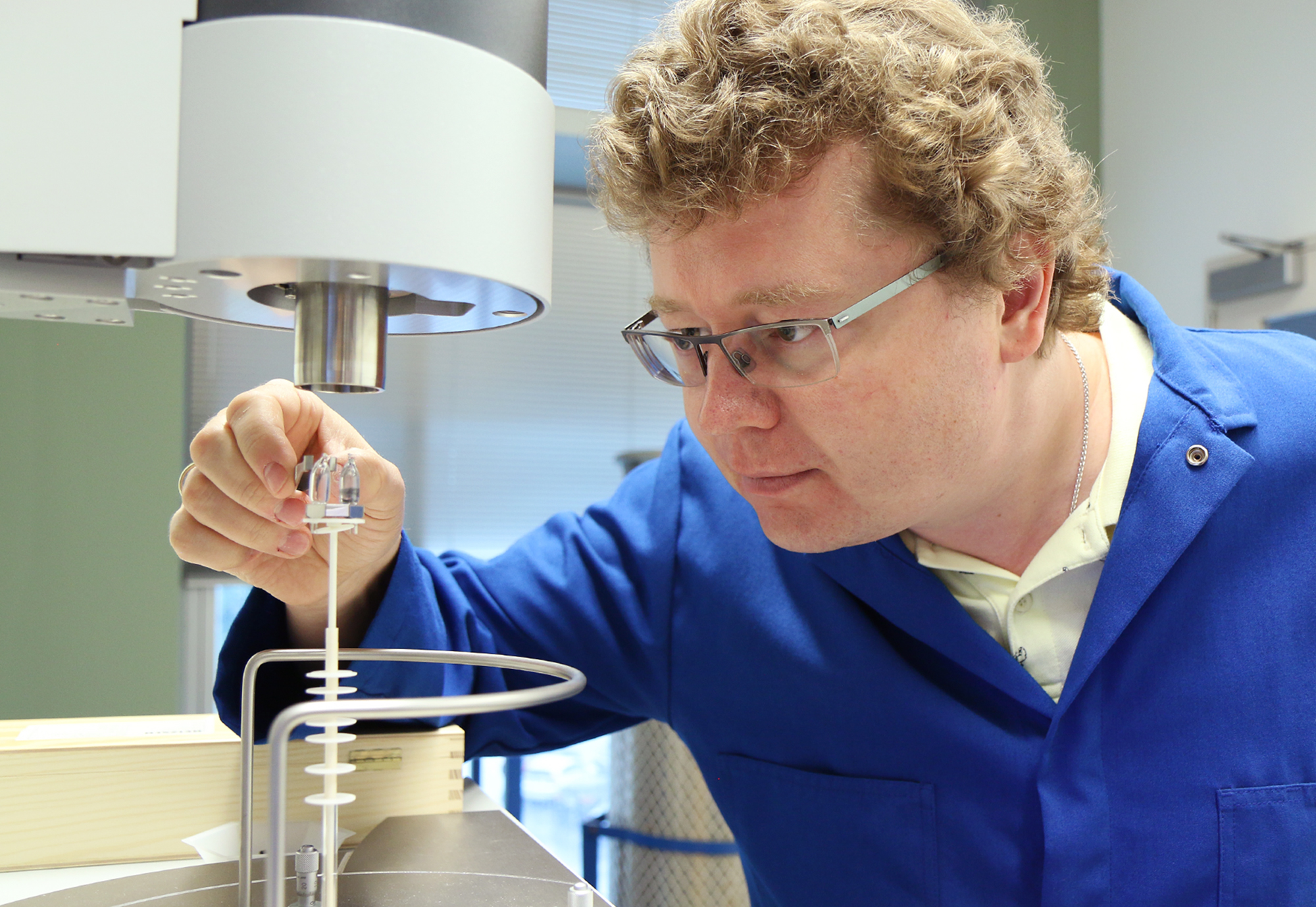 Kirill Kovnir using tweezers to place a small sample inside a machine.