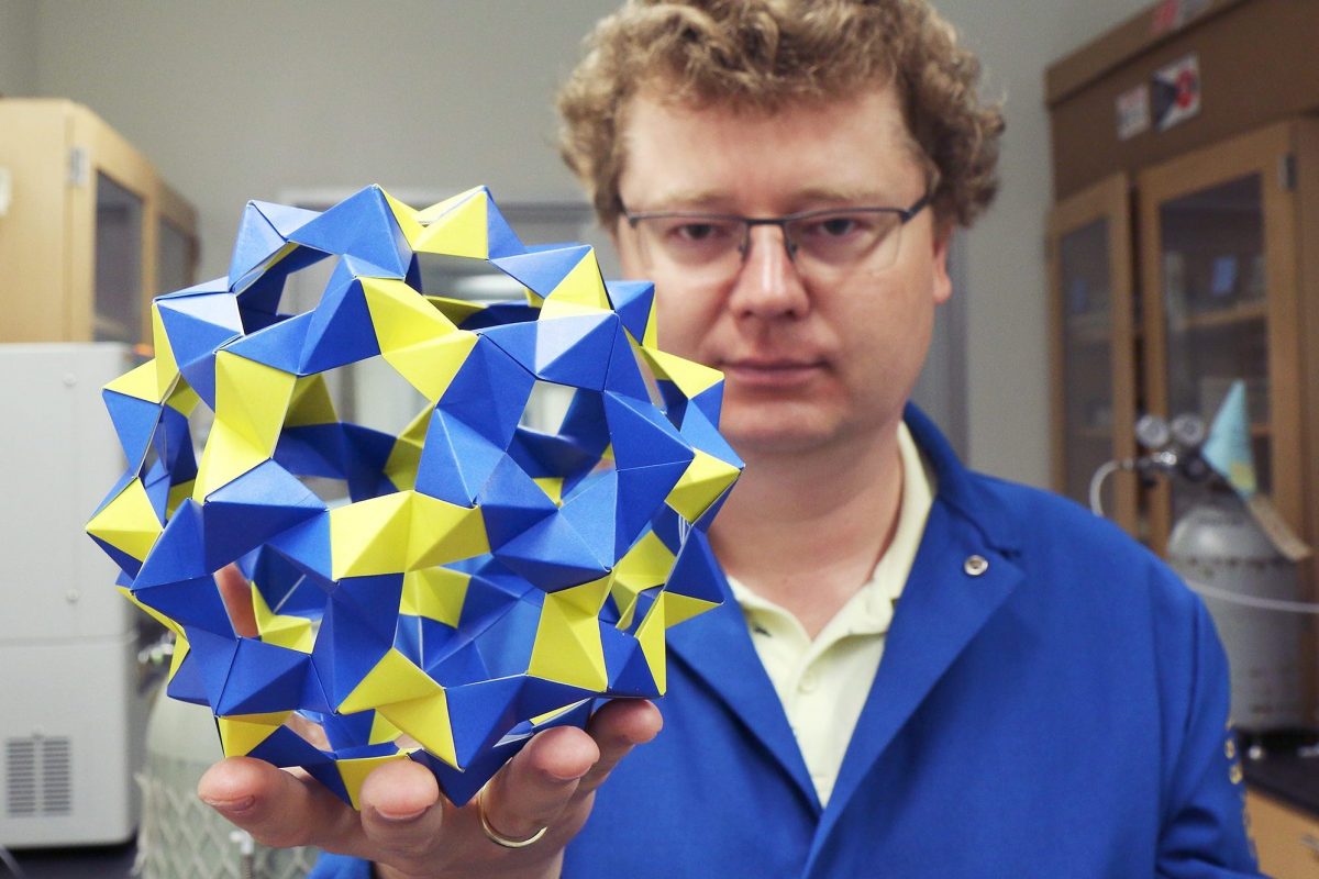 A paper spherical cage is held by Kirill Kovnir.