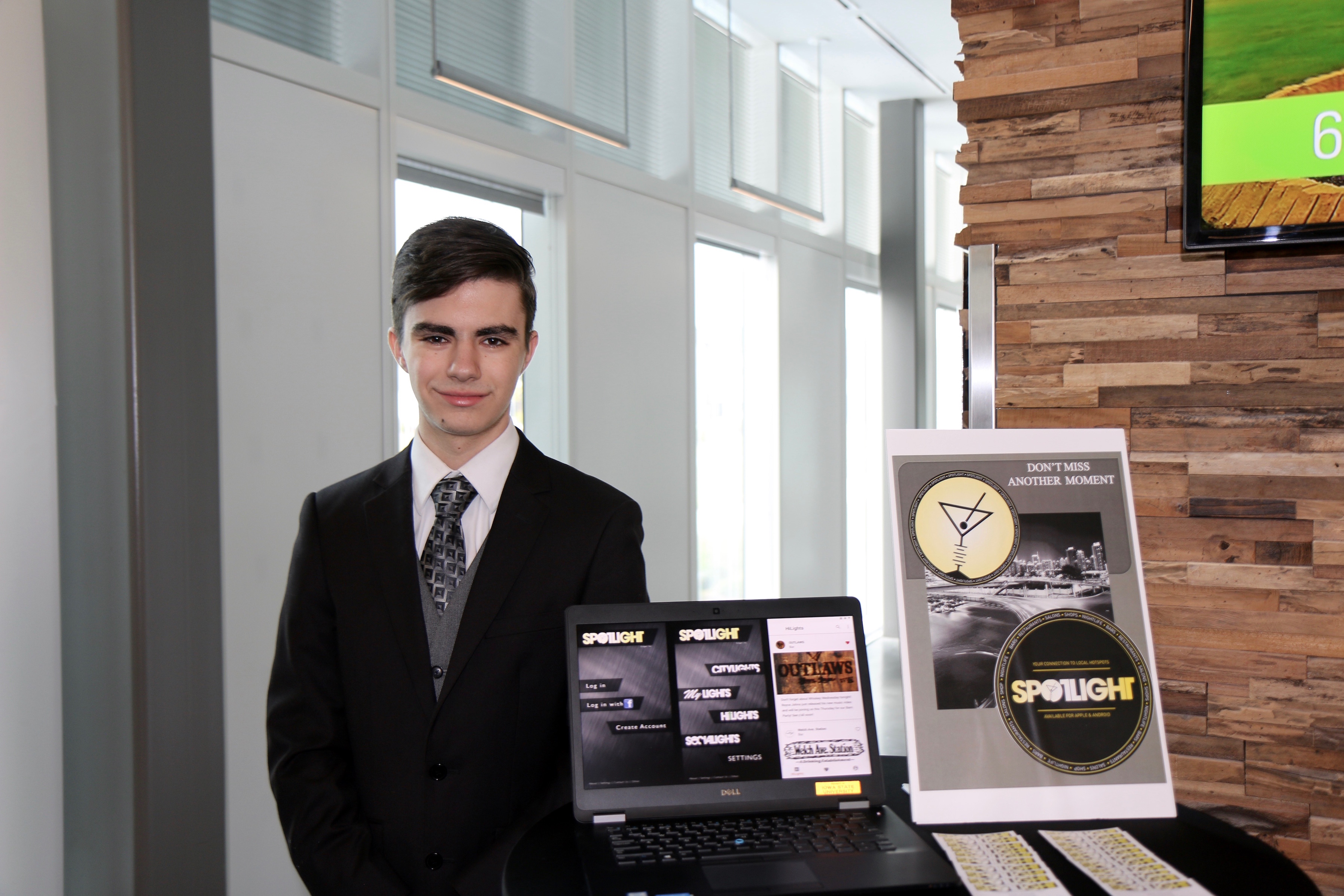 A portrait shot of a man in a business suit next to a table presentation.