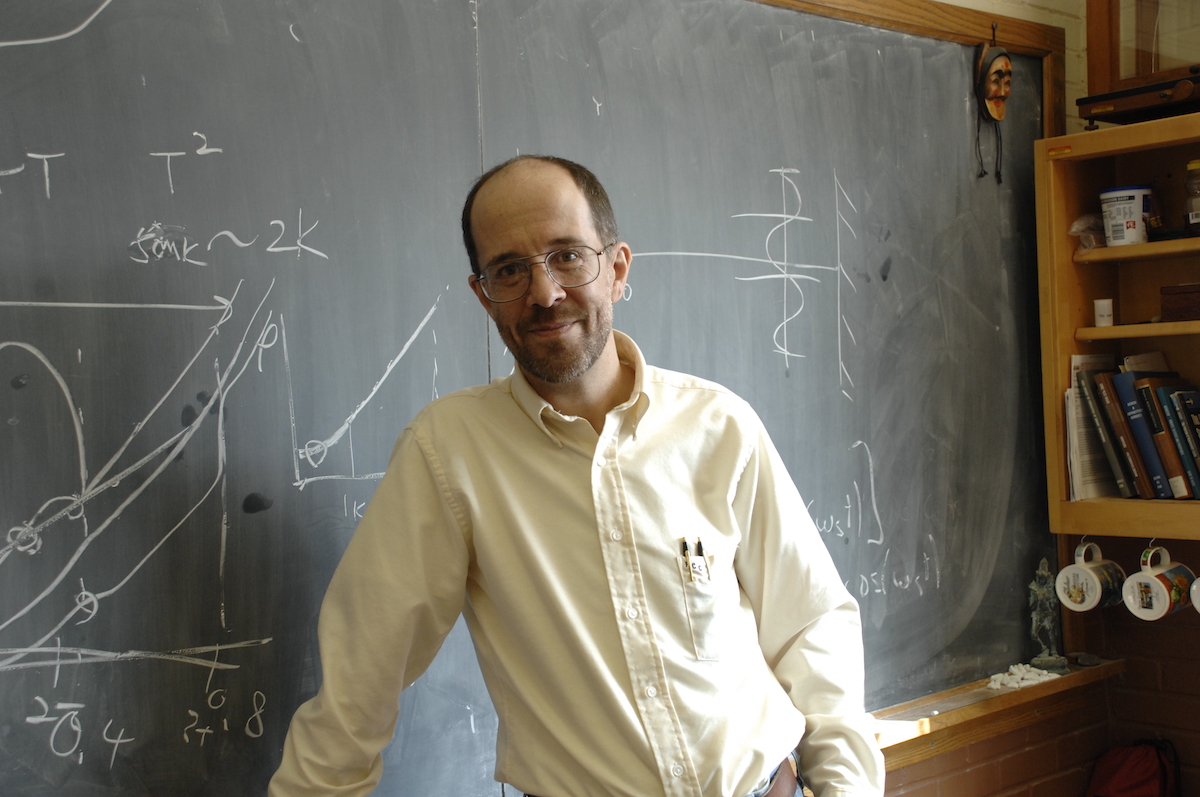 Paul Canfield in front of a blackboard.