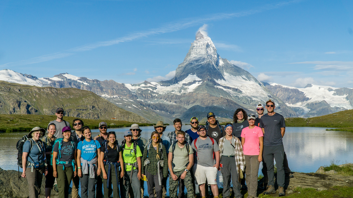 A group of students with a mountain in the background.